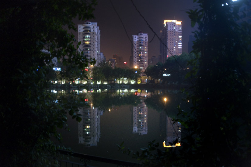 High-rise buildings tower over a lake in the middle of People's Park in Tianjin, China.