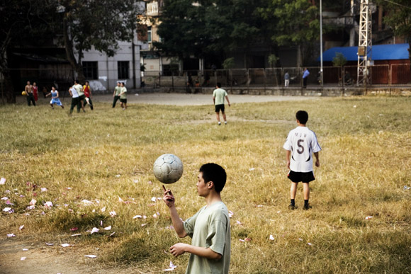Young army recruits play soccer in a field in Hekou, Yunnan Province, China.