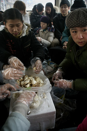 Volunteers ride a rented bus and prepare food for animals at Ha Wenjin's dog and cat rescue farm outside of Nanjing, Jiangsu, China.  Volunteers travel to the farm, a no-kill shelter for stray, injured, and unwanted animals, at least once a week, bringing food and other necessities for the animals.