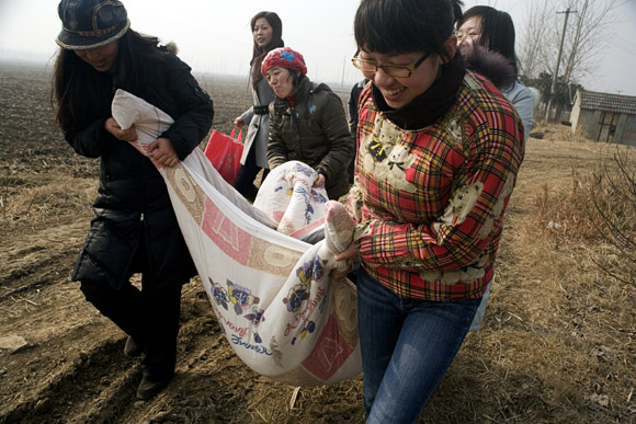 Volunteers carry food, blankets, and other necessities for the dogs and cats at Ha Wenjin's no-kill dog and cat rescue farm outside Nanjing, Jiangsu, China.