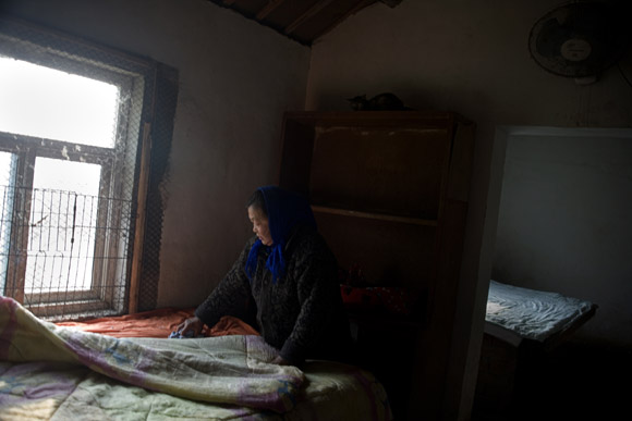 A caretaker tends the bedding provided for cats in a small farmhouse at Ha Wenjin's no-kill dog and cat rescue farm outside Nanjing, Jiangsu, China.