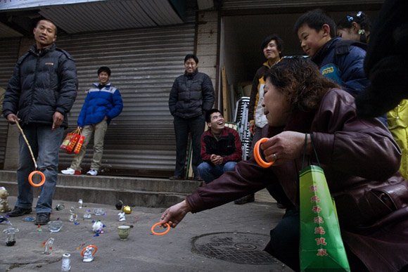 People play a ring-toss game in a Lunar New Year market in Pukou near Nanjing, Jiangsu, China.