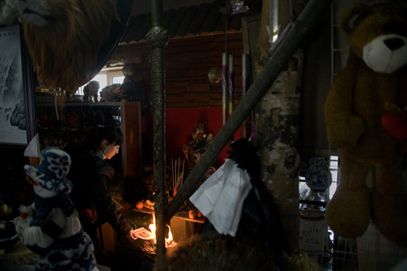 A woman burns ceremonial paper to mark the Lantern Festival, the end of the Lunar New Year and Spring Festival holiday, in a souvenir shop at the Siberian Tiger Park in Haerbin, Heilongjiang Province, China. A woman burns ceremonial paper to mark the Lantern Festival, the end of the Lunar New Year and Spring Festival holiday, in a souvenir shop at the Siberian Tiger Park in Haerbin, Heilongjiang Province, China.