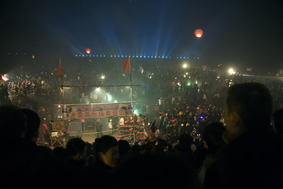 Crowds gather to watch fireworks and lanterns lift into the sky above the frozen Songhua River during Lantern Festival celebrations in central Haerbin, Heilongjiang Province, China.