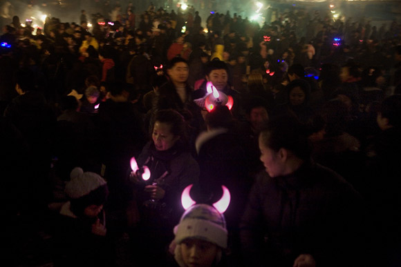 Crowds gather to watch fireworks and lanterns lift into the sky above the frozen Songhua River during Lantern Festival celebrations in central Haerbin, Heilongjiang Province, China.