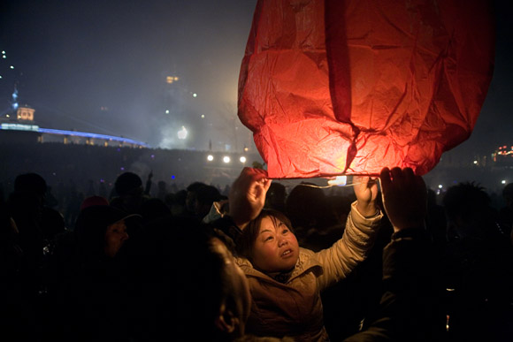 Crowds gather to watch fireworks and lanterns lift into the sky above the frozen Songhua River during Lantern Festival celebrations in central Haerbin, Heilongjiang Province, China.