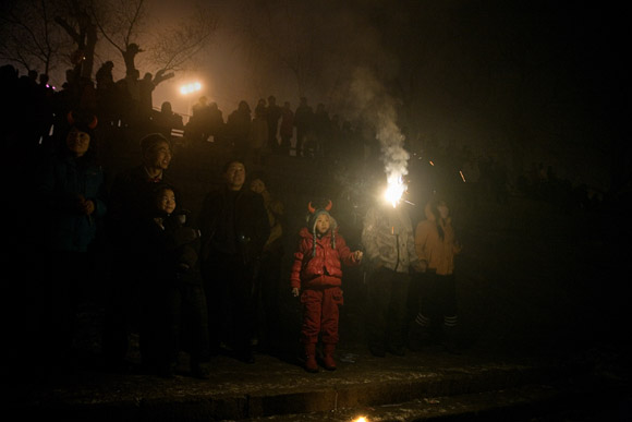 A family lights sparklers and other fireworks in the crowd gathered in Stalin Park on the banks of the Songhua River during Lantern Festival celebrations in central Haerbin, Heilongjiang Province, China.