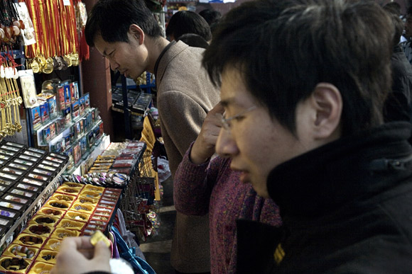 Tourists shop for souvenirs outside the Forbidden City in Beijing, China.