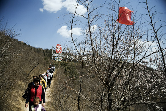 Tourists walk along a trail below the Great Wall at Badaling outside of Beijing, China.