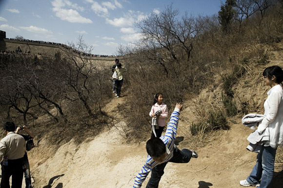 Tourists pose for pictures on a trail below the Great Wall at Badaling outside of Beijing, China.
