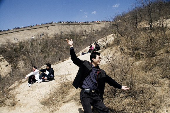 Tourists pose for pictures on a trail below the Great Wall at Badaling outside of Beijing, China.
