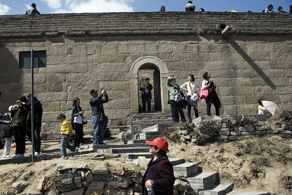 Tourists walk along a trail beneath the Great Wall at Badaling outside of Beijing, China.
