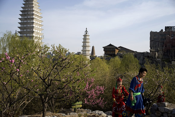 Ethnic minority re-enactors walk among the trails of the Beijing Ethnic Minority Theme Park in Beijing, China.  The park features replica architecture and clothing from all of China's ethnic minorities.