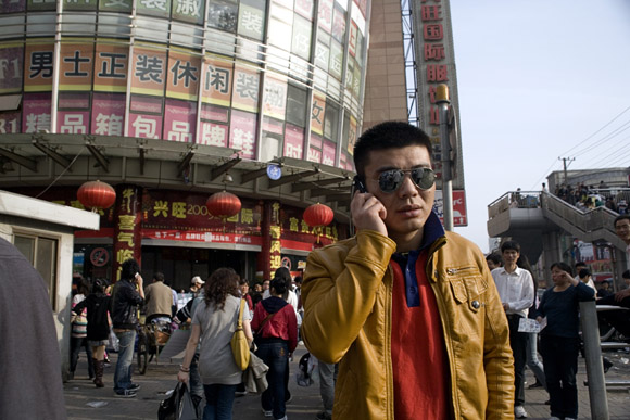 Crowds walk past sellers at a fake designer goods market in central Shanghai, China.