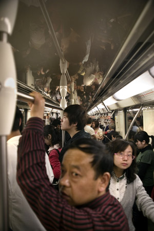 People ride in a crowded subway car in Shanghai, China.