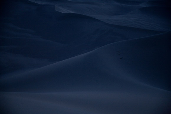The moon illuminates the dunes of the Gobi Desert at night near Dunhuang, Gansu, China.  An area of the desert near this dune will be the site of the world's largest solar power generating field.