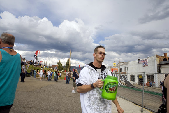 A man walks with a large Mountain Dew mug in Butte, Montana, USA.