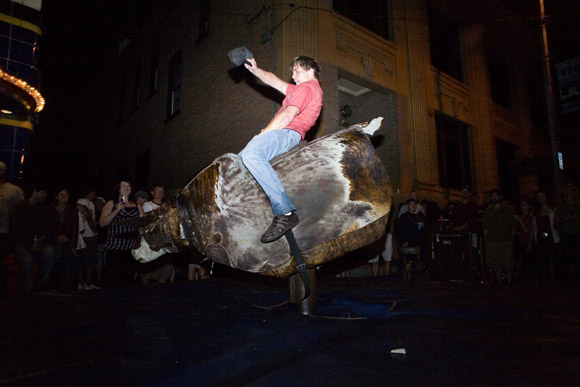 Revelers attempt to ride a mechanical bull late at night during the Evel Knievel Days festival in Butte, Montana, USA.