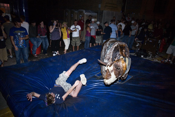 Revelers attempt to ride a mechanical bull late at night during the Evel Knievel Days festival in Butte, Montana, USA.