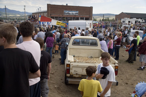 The crowd listens to the National Anthem before Spanky Spangler's daredevil car jump stunt at the end of Evel Knievel Days in Butte, Montana, USA.