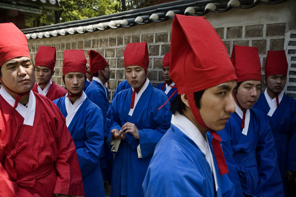 Young men wait for a ceremony to begin during the Jongmyodaeje Festival outside the Jeongjeon Temple at the Jongmyo Shrine in Seoul, South Korea.